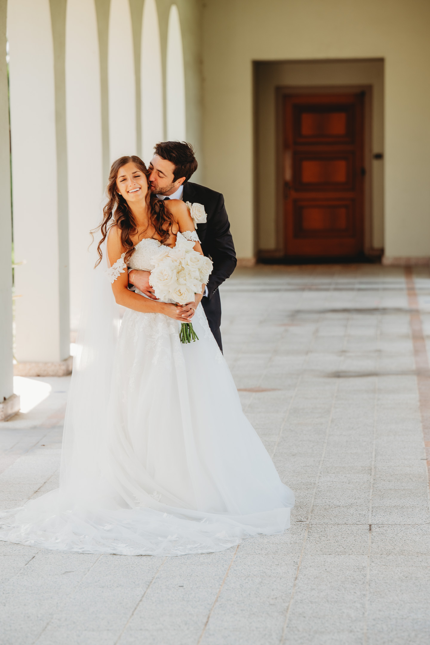 Bride and groom embracing under an archway