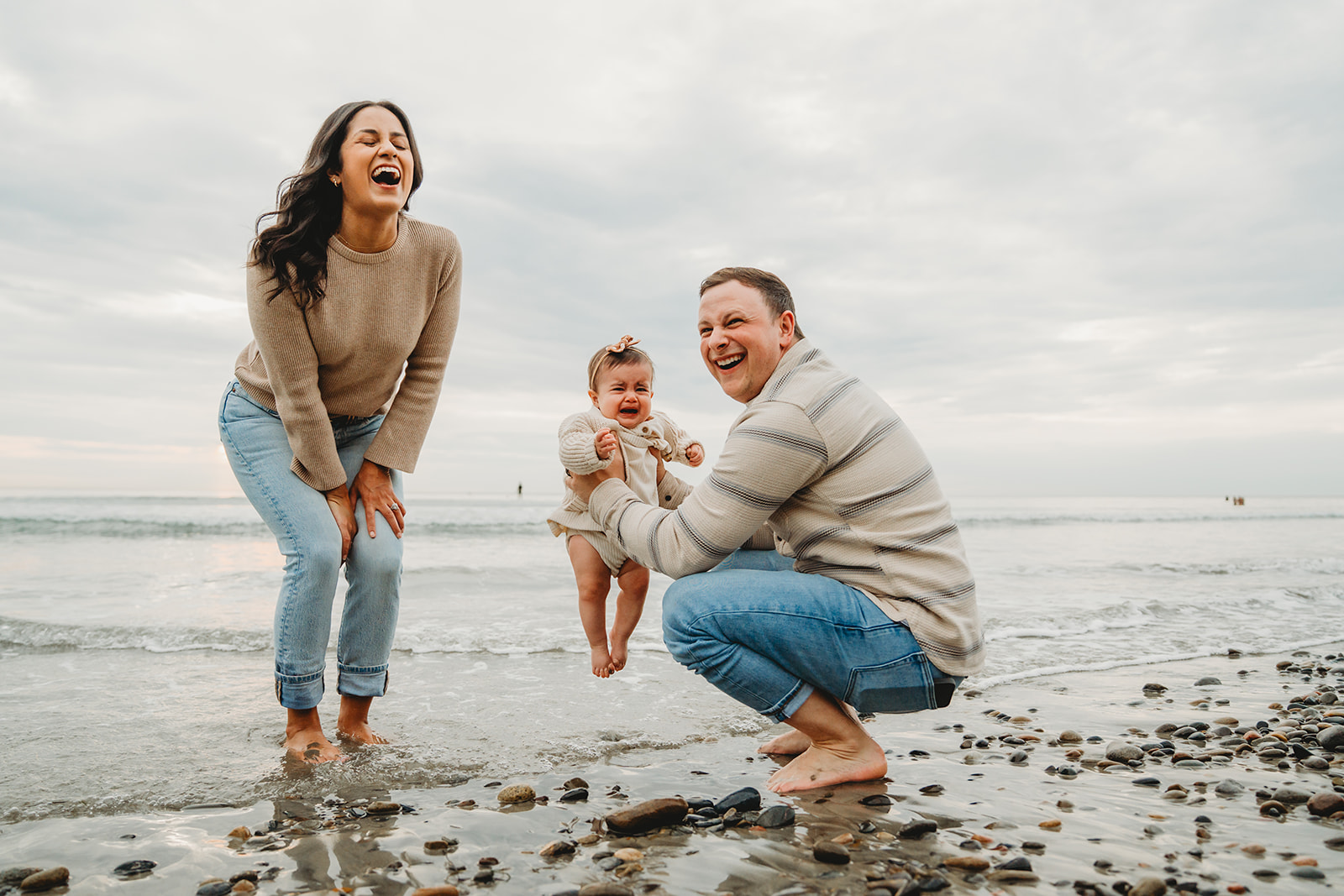 Jeans and cream sweaters, an easy laughing moment on the beach