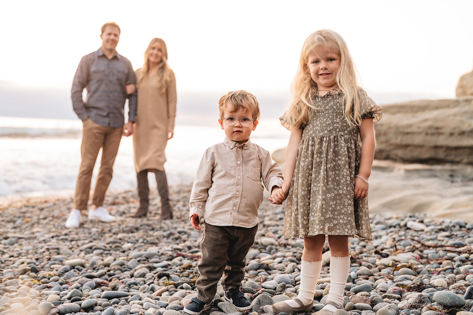 Family in neutral tans and creams on a pebble beach, always a hit